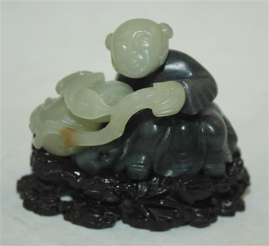 A Chinese pale celadon and dark grey jade and stand